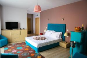 a bedroom with a blue bed and a tv at Sangria Luxury Family in Mamaia Nord +95 photos