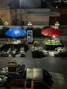 two umbrellas in front of a market in the rain at bége in Ban Lo Long