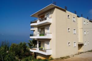 a building with balconies on the side of it at Sunshine Guesthouse Dhermi in Dhërmi