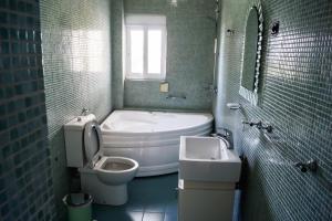 a bathroom with a tub and a toilet and a sink at Sunshine Guesthouse Dhermi in Dhërmi +91 photos