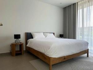 a white bedroom with a large bed and a window at Glenwood Sanctuary Villa Hồ Tràm Villa 85 in Ho Tram +38 photos