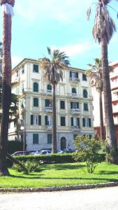 斯培西亚DOWNTOWN SRL - Waterfront Cinque Terre的一座前面有棕榈树的大楼