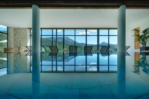 a rendering of a room with a pool and windows at Kräuterhotel Zischghof in Obereggen