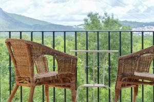 two wicker chairs and a table in front of a fence at Retiro do Bosque Country House in Minde