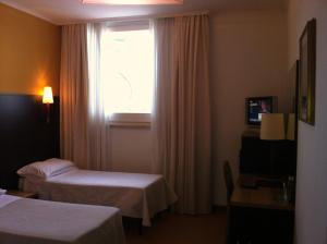 a hotel room with two beds and a window at Hotel Villa Alessandra in Alanno