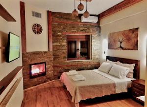 a bedroom with a brick wall and a bed at Petroula Suites Pozar in Kato Loutraki