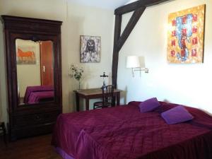 a bedroom with a purple bed and a mirror at Au Château Des Thermes in Saint-Amand-les-Eaux