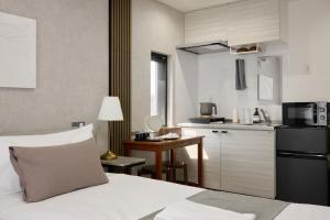a bedroom with a bed and a small kitchen at ルチル池袋東京 in Tokyo