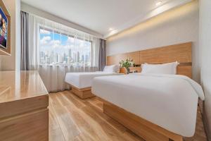 a hotel room with two beds and a window at GreenTree Inn Haixi Geermu Southern suburbs Express Hotel in Golmud +118 photos