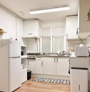 a kitchen with white appliances and white cabinets at Luna stay in Seoul +31 photos