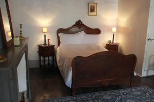 ein Schlafzimmer mit einem großen Bett mit zwei Nachttischen in der Unterkunft "Number 26" Town House in Rochefort-en-Terre