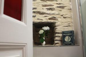 a vase of flowers on a window in a stone wall at "Number 26" Town House in Rochefort-en-Terre