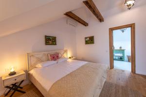 a bedroom with a large white bed and a wooden floor at Old Barn House in Vàrhegy