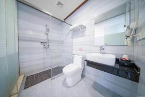 ein Badezimmer mit Toilette, Waschbecken und Dusche in der Unterkunft Jun Hotel Guangxi Wuzhou Changzhou District Fengye Garden in Wuzhou