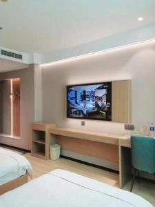 Cette chambre dispose d'une télévision murale. dans l'établissement GreenTree Inn Taiyuan Xinghua Street, à Taiyuan