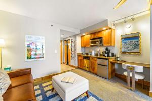 a living room with a kitchen with a couch and a table at Perfect Location Hot Tub Heated Pool Steam Room Gym in Mount Crested Butte