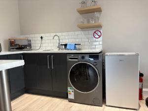 a kitchen with a washing machine and a sink at Metanoia Kingswood Golf Estate in George
