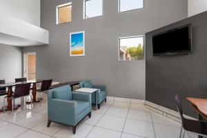 a dining room with a table and a tv at Days Inn by Wyndham Phoenix West in Phoenix