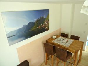 a dining room table with chairs and a painting on the wall at Haus Salzberg in Hallstatt