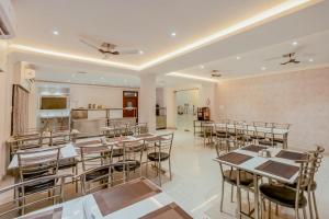 a restaurant with tables and chairs and a kitchen at Binayak Palace Premium in Kendrāparha