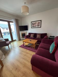 ein Wohnzimmer mit einem lila Sofa und einem Tisch in der Unterkunft Luxury stylish Kincora Townhouse in Killaloe