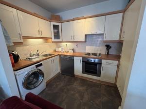 eine Küche mit weißen Schränken und einer Waschmaschine in der Unterkunft Luxury stylish Kincora Townhouse in Killaloe + 4 Fotos
