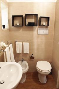 ein Badezimmer mit einer weißen Toilette und einem Waschbecken in der Unterkunft Casa MariFer in Scicli