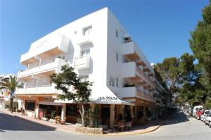 a large white building on the side of a street at Hotel Sa Volta in Es Pujols