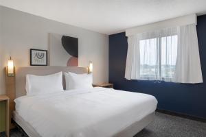 a bedroom with a large white bed and a window at Spark by Hilton Carlisle South in Carlisle