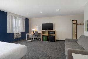 a hotel room with a bed and a tv and a couch at Spark by Hilton Carlisle South in Carlisle