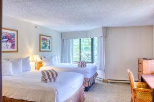 una camera d'albergo con due letti e una finestra di 1 Bedroom Condo Perfect Location #303 with Pool and Hot Tub a Mount Crested Butte