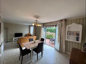 Una sala de estar con una mesa y sillas y un sofá. en Clos des hortensias, en Fatouville-Grestain 14 fotos más