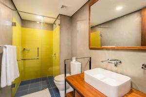 een badkamer met een wastafel, een toilet en een spiegel bij Lake Avenue Hotel Kandy in Kandy