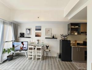 ダバオシティにあるCypress Elysium - Davao Condo Near Airport & Mallsのキッチン、リビングルーム(テーブル、テレビ付)