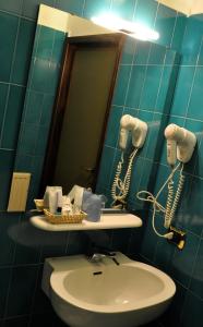 La salle de bains est pourvue d'un lavabo et d'un miroir. dans l'établissement Albergo Della Corona, à Binasco