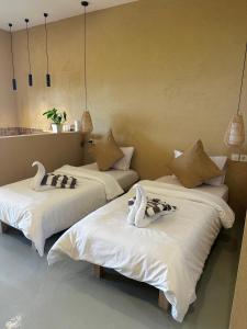two beds with swans on them in a room at Jepun Hill Studios & Amed Jepun Divers in Amed +41 photos