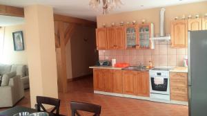 - une cuisine avec des placards en bois et une cuisinière dans l'établissement Apartament Mikołajki, à Mikołajki