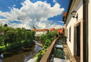 捷克克魯姆洛夫的住宿－坢休恩泰迪酒店，享有河流和建筑景致的阳台