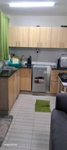 a kitchen with wooden cabinets and a stove top oven at Swanky Stays Studio Ngong in Nairobi