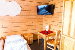 a room with a bed and a table with a tv at Willa pod Granią in Białka Tatrzańska