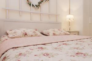 a bedroom with a bed with pink flowers on it at Romantic apartment near Opera with Air-conditioning in Lviv