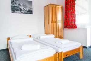 two beds in a room with a red curtain at Willa pod Granią in Białka Tatrzańska