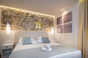 Un dormitorio con una cama grande con una pared de piedra. en Balatura The Fine Bed&Breakfast Split, en Split