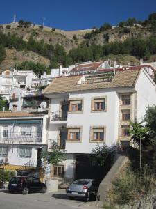 a white building with cars parked in front of it at Apartamentos La Iruela 2 in La Iruela