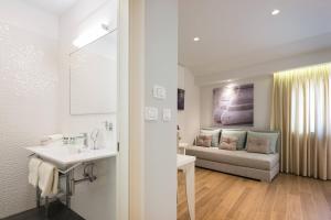 baño con lavabo y sala de estar con sofá. en Balatura The Fine Bed&Breakfast Split, en Split 115 fotos más