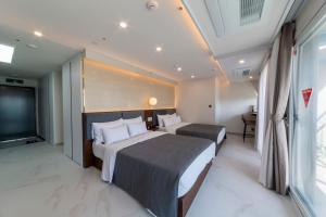 a hotel room with two beds and a flat screen tv at Raviens Maison de Hotel in Busan +58 photos