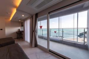 a room with a large window with a view of the ocean at Raviens Maison de Hotel in Busan