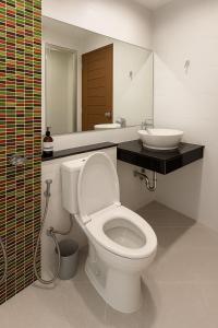 a bathroom with a white toilet and a sink at VONLUCK-Wonnapha Beach in Ban Bang Saen (1)