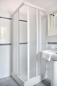 a white bathroom with a shower and a sink at B&B La Castellana in Marina di Ragusa