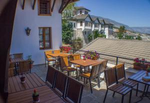 a patio with tables and chairs on a balcony at Old Bazaar 1790 in Gjirokastër